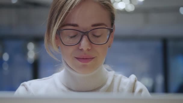 Retrato de close-up de uma menina com óculos trabalhando em um laptop — Vídeo de Stock