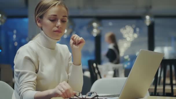 Ragazza come uno scrittore mette gli occhiali e inizia a lavorare su un computer portatile — Video Stock