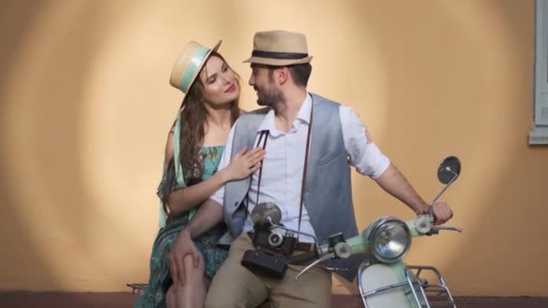 Gars et fille sont assis sur un scooter vintage. couple amoureux se touchent doucement . — Video