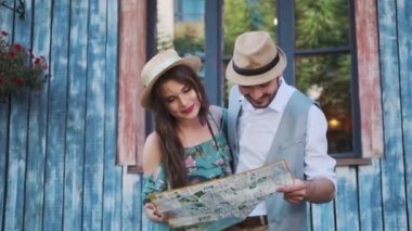turistler çift seyahat harita keşfetmek vardır. bir genç kadın ve bir adam bir yolculuğa şehir etrafında yürümek
