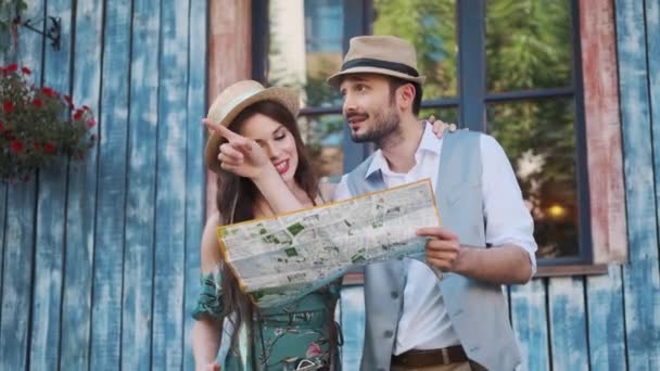 Turistler çift seyahat harita keşfetmek vardır. bir genç kadın ve bir adam bir yolculuğa şehir etrafında yürümek — Stok video