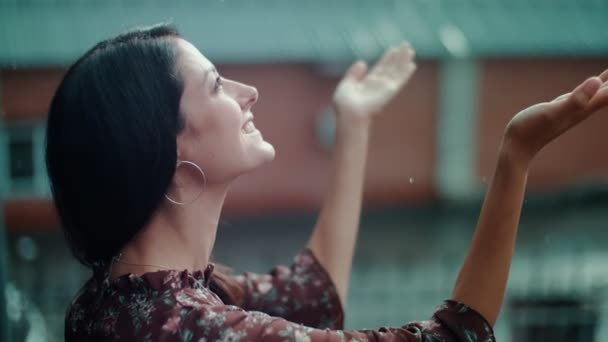 Ung kvinna lägger händerna i regnet, jublar, skrattar och ler — Stockvideo