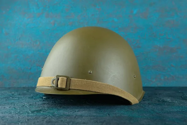 Old military helmet from the Second World War on cement background.