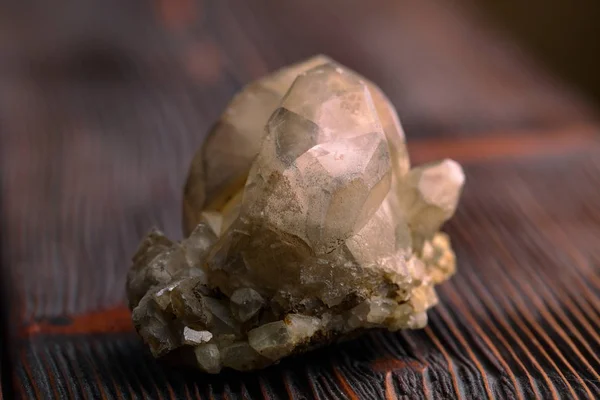 Rock crystal mineral stone on the wooden background. Quartz variety.