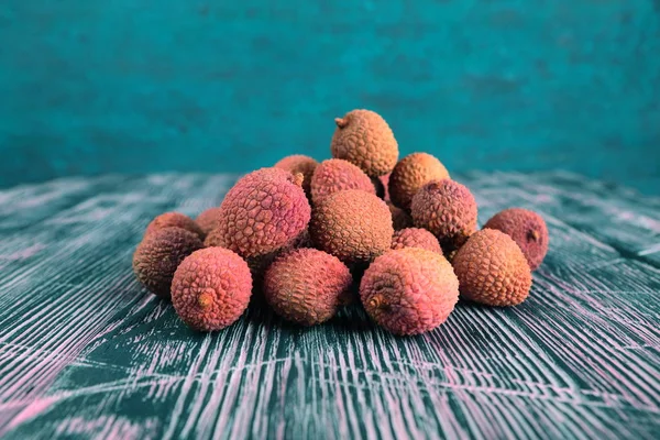 Lychee on a black and pink wooden background