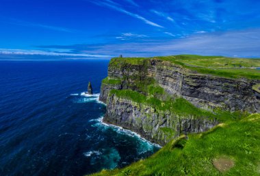 Moher İrlandalı kayalıklarla masmavi gökyüzü altında