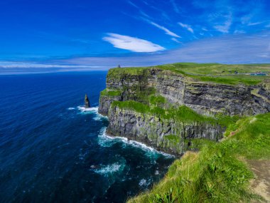 Moher İrlandalı kayalıklarla masmavi gökyüzü altında