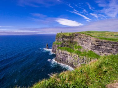 Moher İrlandalı kayalıklarla masmavi gökyüzü altında
