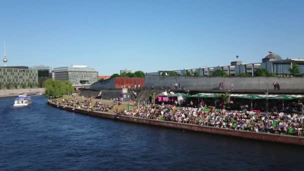 İnsanlar Berlin 'deki River Spree kıyısında sıcak bir yaz gününün tadını çıkarıyorlar. — Stok video