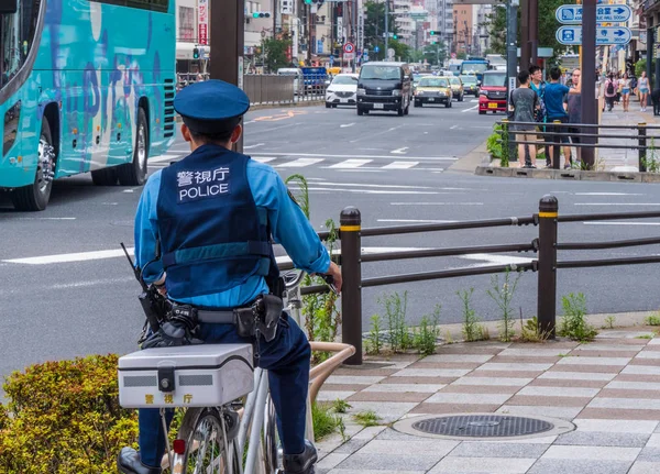 Japon polis memuru, Tokyo - Tokyo, Japonya - 12 Haziran 2018 sokaklarında bir bisiklet üzerinde