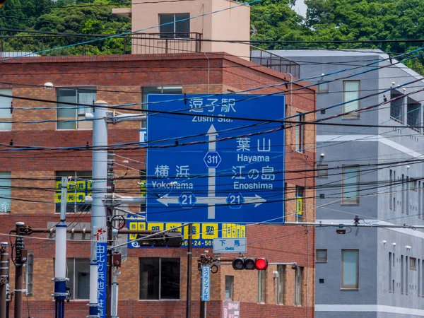 Κατεύθυνση πινακίδα πίσω από το ηλεκτρικά καλώδια στους δρόμους της Καμακούρα - Τόκιο, Ιαπωνία - 12 Ιουνίου 2018 — Φωτογραφία Αρχείου