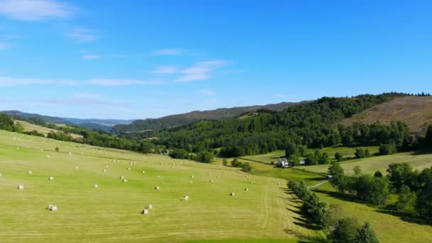 Vuelo sobre campos verdes y tierras de cultivo con fardos de heno en Escocia — Vídeo de stock