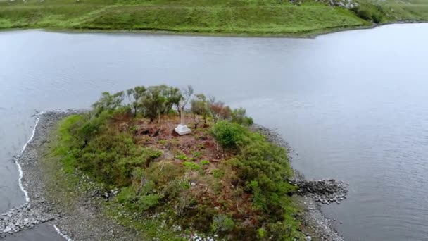 Tiny wyspie na środku jeziora w Scottish highlands - lot lotnicze drone — Wideo stockowe