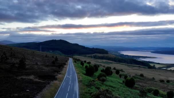 Vuelo sobre un camino solitario a lo largo de Loch Shin en Escocia - vista de la noche — Vídeo de stock