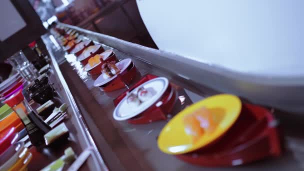 Бег суши-бар - тарелки со свежеприготовленными суши на лодках — стоковое видео