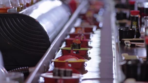 Пробіг суші-бар - тарілки зі свіжозробленими суші на човнах — стокове відео