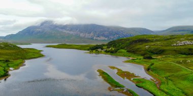Küçük göl ve dere İskoçya'nın dağlık üzerinde havadan görünümü