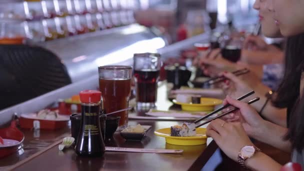 Les gens qui mangent des sushis dans un restaurant Running Sushi — Video