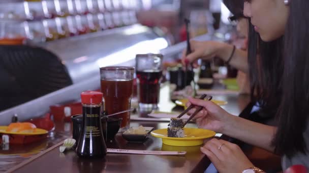 Les gens qui mangent des sushis dans un restaurant Running Sushi — Video