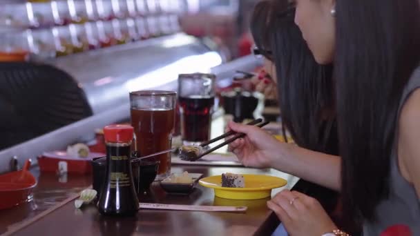 Люди едят суши в ресторане Running Sushi — стоковое видео