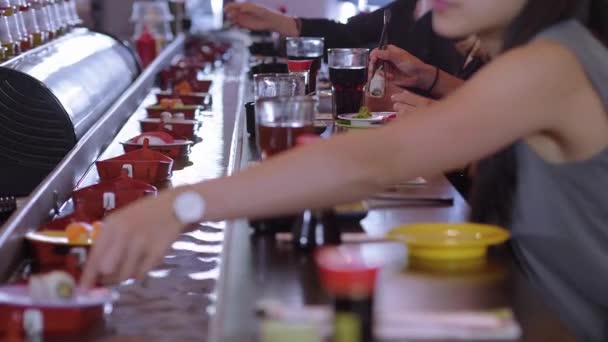 Gente comiendo Sushi en un restaurante Running Sushi — Vídeos de Stock