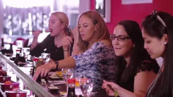 Skupina dívek sedět v restauraci Sushi Bar a jíst asijských potravin — Stock video