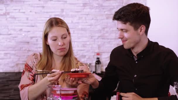 Jeune couple dans un réataurant Sushi - manger des Sushi fraîchement préparés à partir du buffet — Video