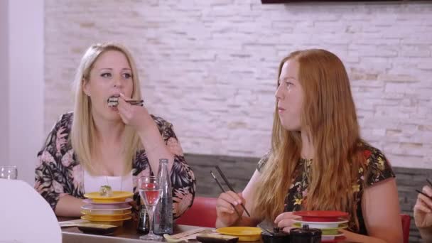 Deux belles filles mangent des sushis dans un bar — Video