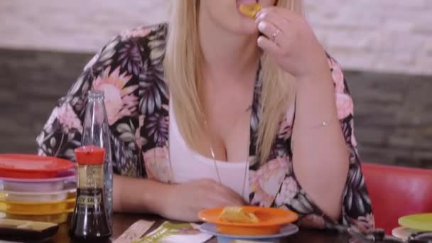 Mujer joven come comida con los dedos en un restaurante asiático de sushi — Vídeo de stock