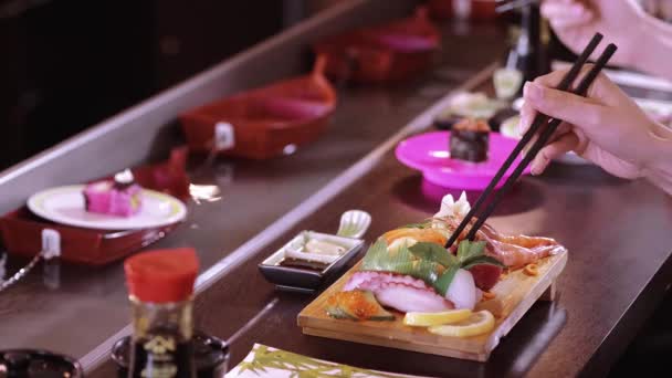 Comer sushi con palillos en un restaurante asiático - tiro de cerca — Vídeos de Stock