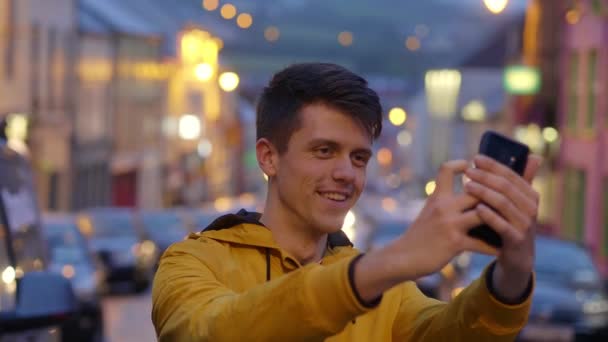 Junger Mann macht ein Selfie mit dem Handy — Stockvideo