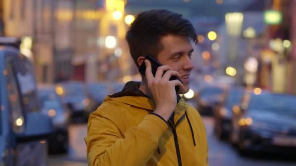 El joven está hablando con su amigo en el celular. — Vídeo de stock