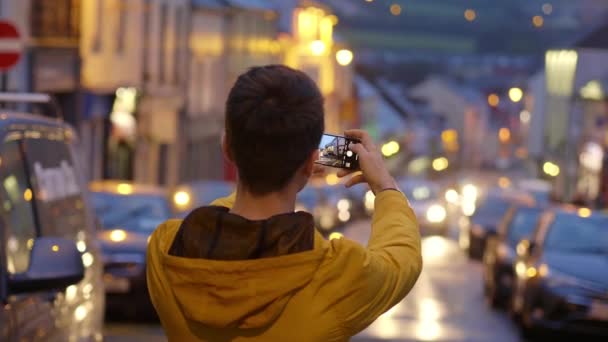 Young guy takes photos with the mobile phone — Stock Video