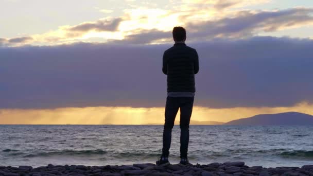 Joven en la playa al atardecer — Vídeo de stock