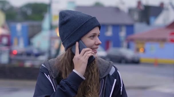 Jovem bela mulher atende um telefonema em seu celular — Vídeo de Stock