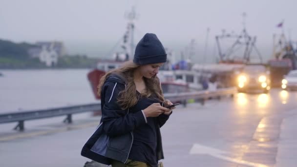 Jeune fille écrit un message texte sur le téléphone mobile — Video