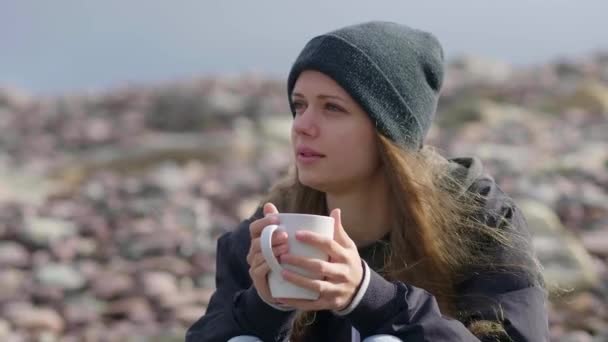 Primer plano de una chica con una taza de café en sus manos — Vídeos de Stock