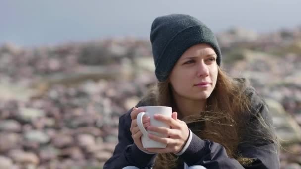 Primer plano de una chica con una taza de café en sus manos — Vídeos de Stock