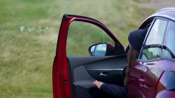 Meisje komt uit haar auto en kijkt over het landschap — Stockvideo