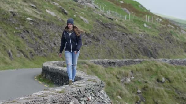 Κορίτσι περπατά επάνω σε έναν τοίχο κατά μήκος του δρόμου — Αρχείο Βίντεο