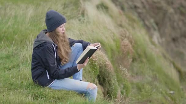 Idealne miejsce do wypoczynku - czytanie książki w polach trawy szeroko otwarte — Wideo stockowe