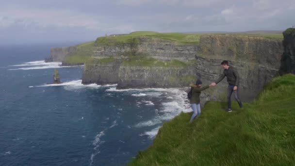 Verliefde paar wandelingen langs de kliffen van Moher in Ierland — Stockvideo