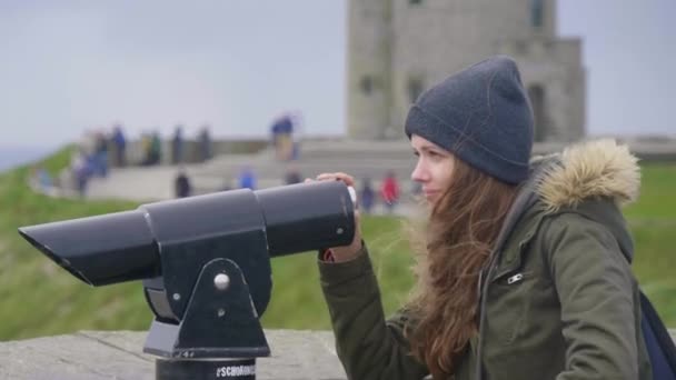 Hezká dívka vypadá přes dalekohled — Stock video