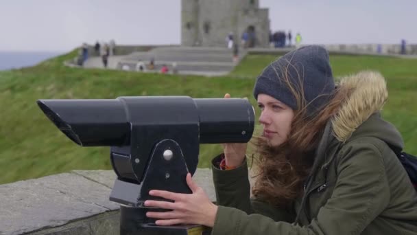 Young woman checking the surroundings through a spyglass — Stock Video