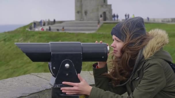 Young woman checking the surroundings through a spyglass — Stock Video