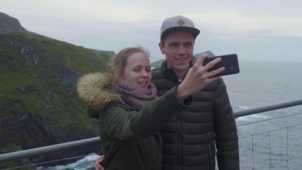 Dos jóvenes toman fotos y selfies en los acantilados de Kerry — Vídeo de stock