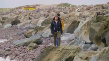 İki arkadaş İrlandalı sahilinde kayaların üzerinde tırmanmaya