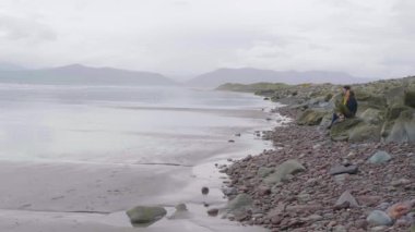 İki arkadaş İrlandalı west coast yalnız bir kumsalda oturup