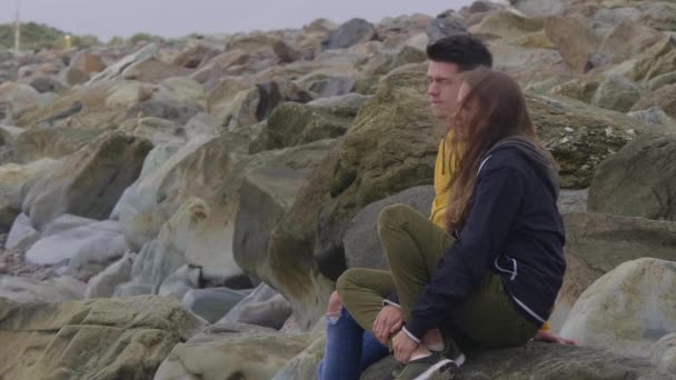 Dos amigos se sientan en la playa y disfrutan de la vista sobre el océano — Vídeos de Stock