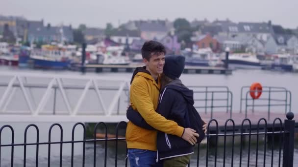 Joven chico abraza a su novia y disfruta de la maravillosa aldea de Dingle en Irlanda — Vídeo de stock